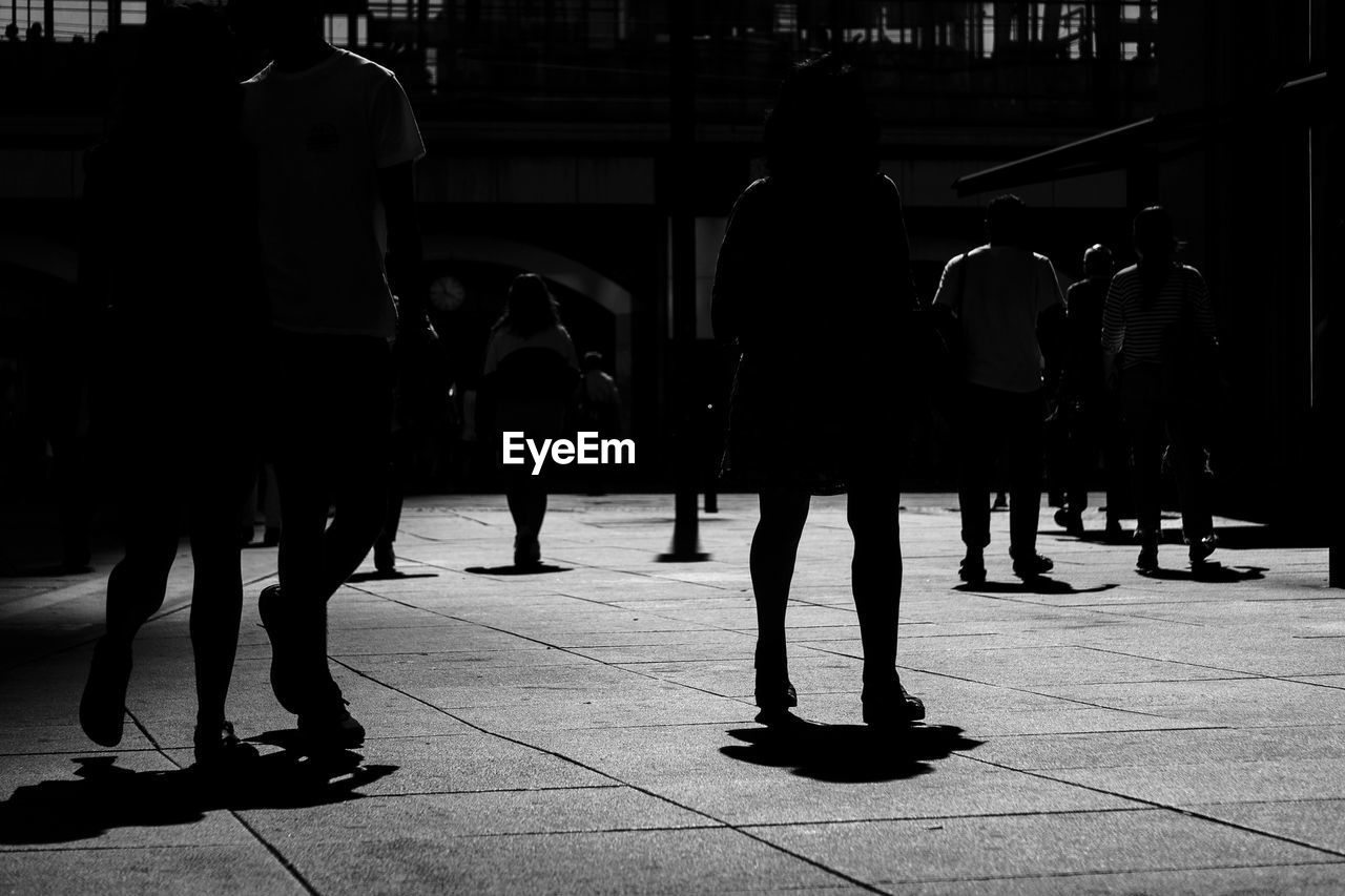 PEOPLE WALKING ON SIDEWALK IN CITY
