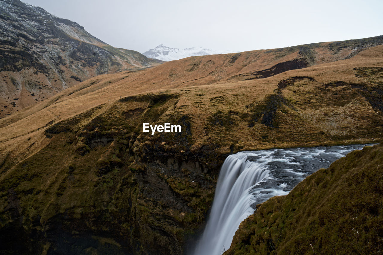 Scenic view of waterfall by rock formation