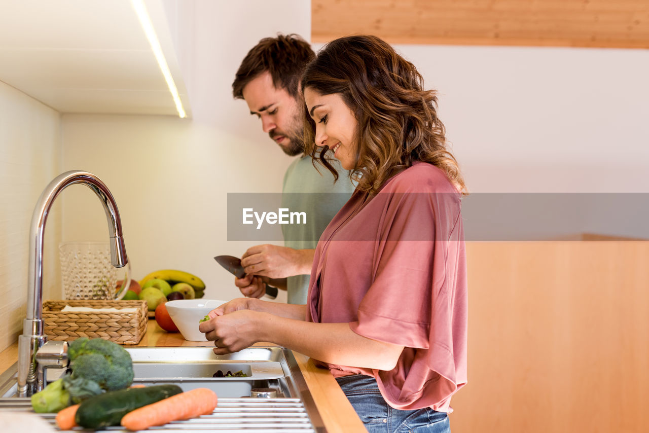 Couple preparing food together in kitchen at home