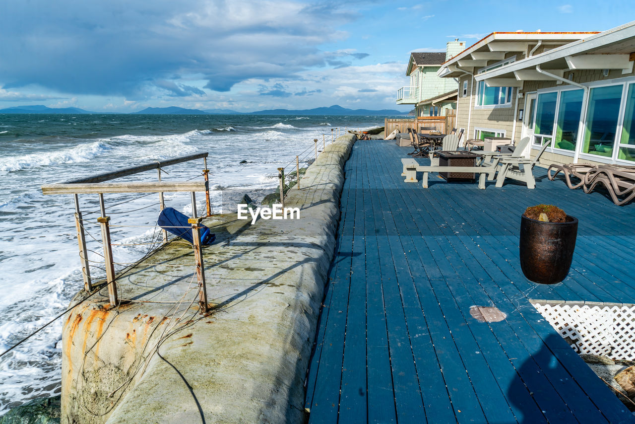 water, sea, sky, vacation, nature, ocean, beach, land, coast, architecture, wood, travel destinations, travel, dock, nautical vessel, cloud, scenics - nature, transportation, pier, vehicle, beauty in nature, holiday, trip, built structure, no people, outdoors, day, shore, tranquility, blue, tourism, boat, sunlight, environment, mode of transportation, building exterior, tranquil scene, coastline, landscape