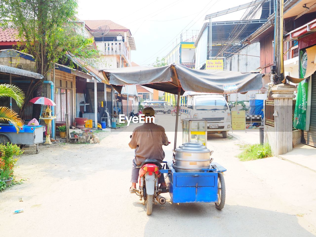 REAR VIEW OF MAN WALKING ON STREET