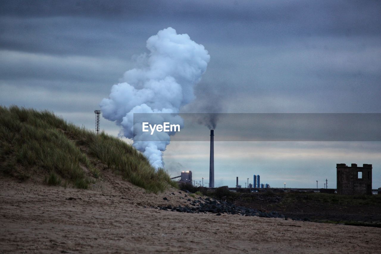 Smoke emitting from chimney against sky