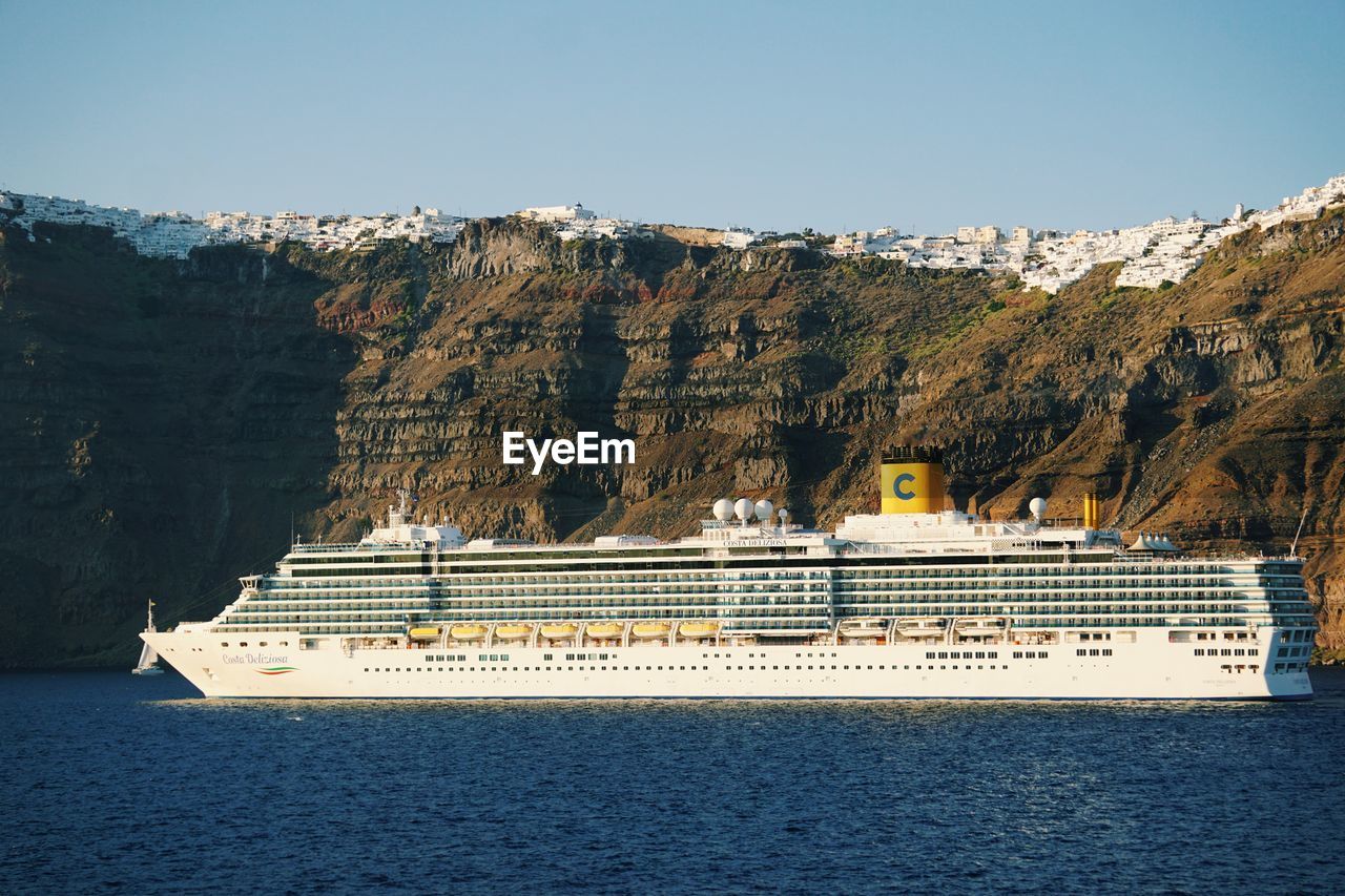 SCENIC VIEW OF SEA AGAINST MOUNTAIN