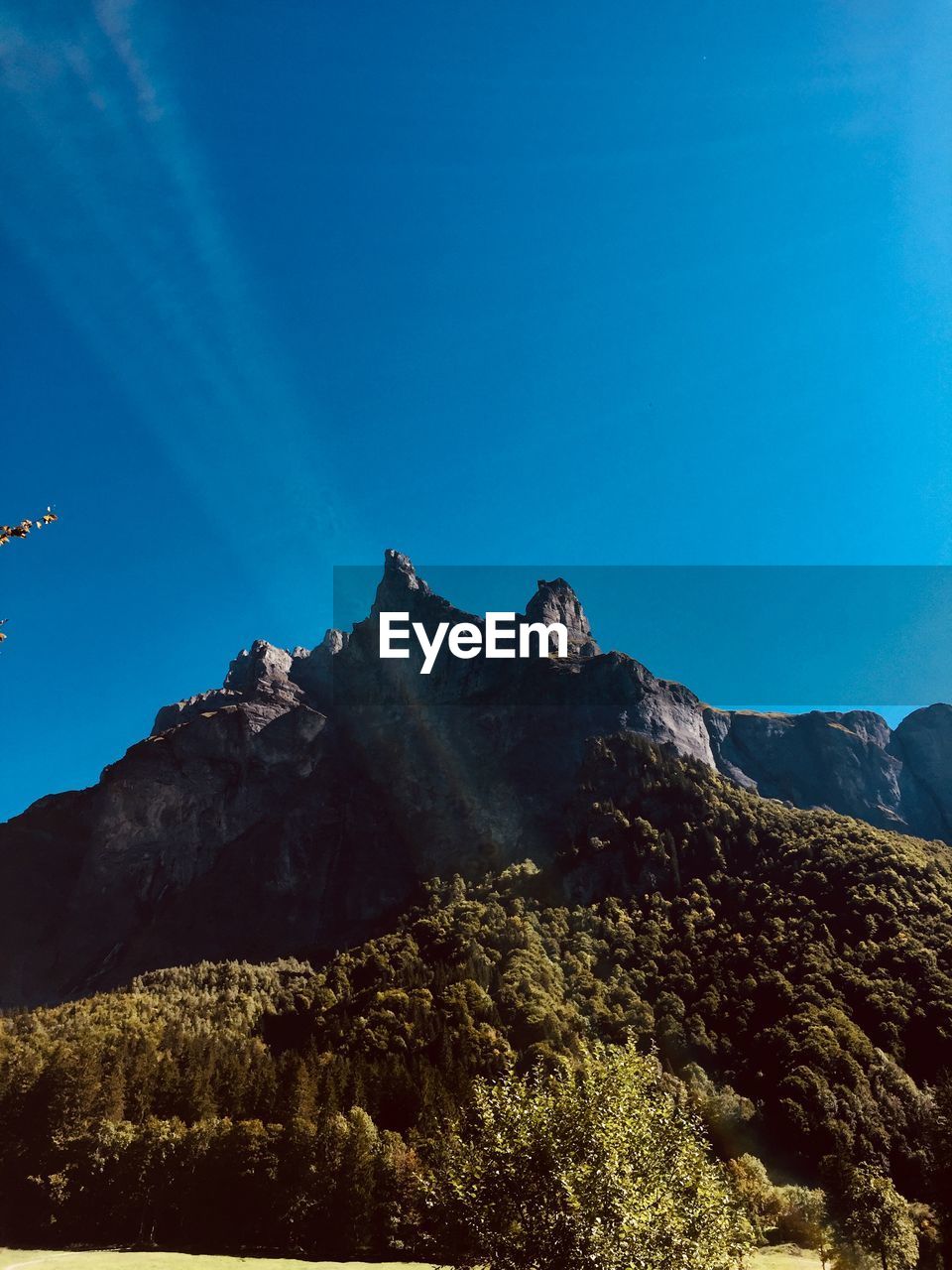 Low angle view of mountain against blue sky