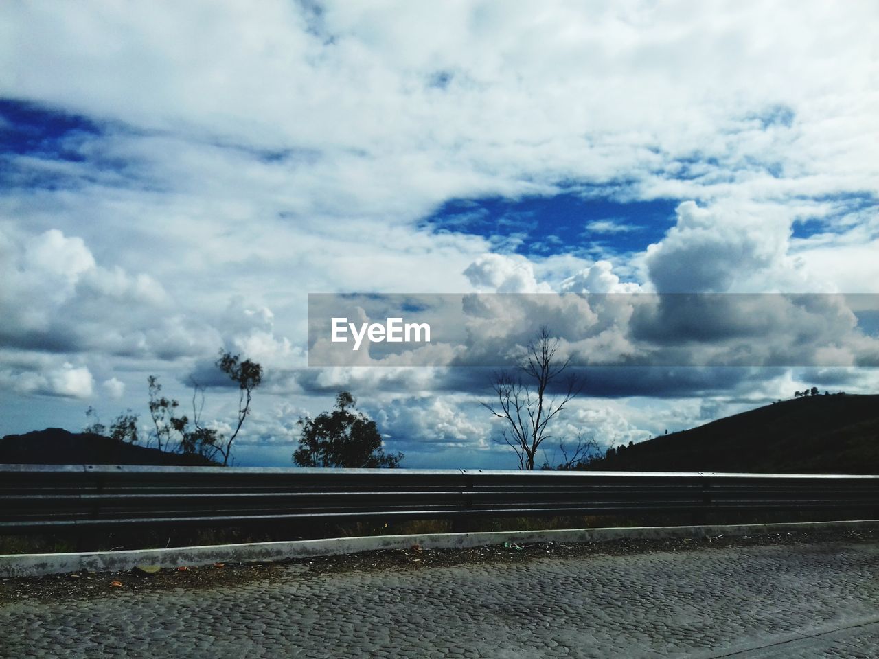 CLOUDS OVER LANDSCAPE AGAINST CLOUDY SKY