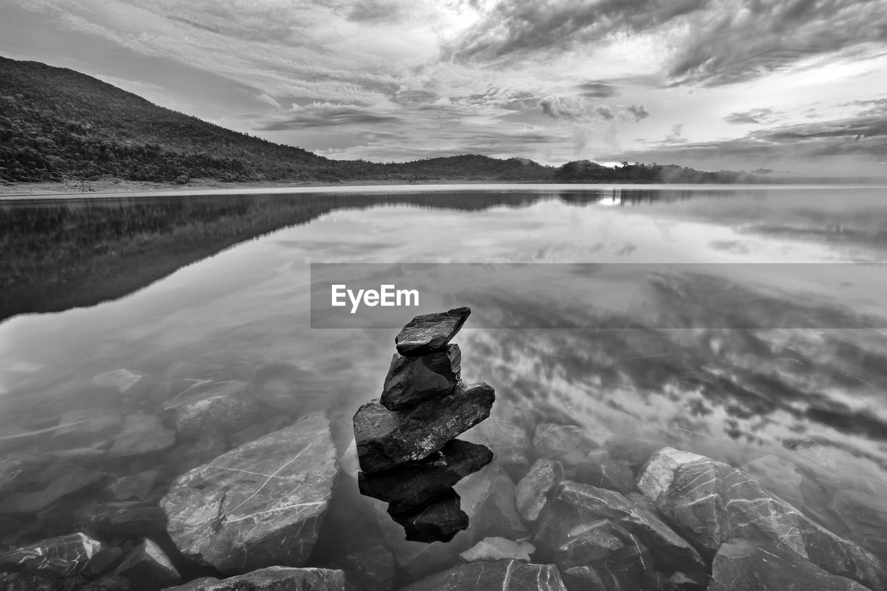 Scenic view of calm lake against cloudy sky