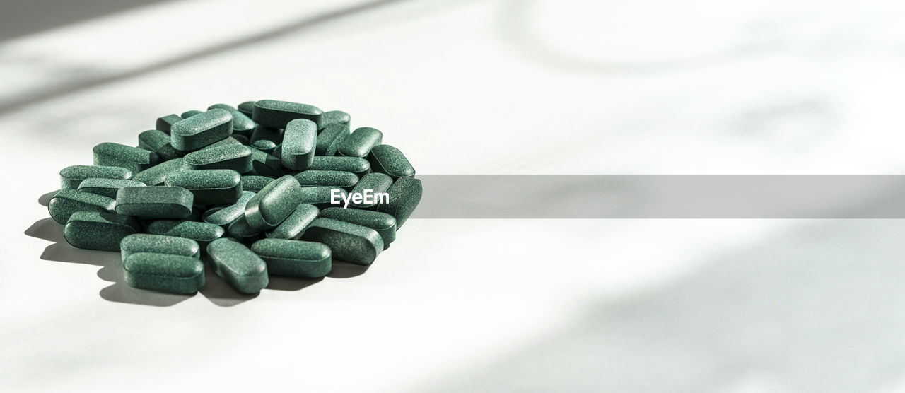 healthcare and medicine, medicine, pill, dose, capsule, large group of objects, green, nutritional supplement, close-up, vitamin, science, indoors, jewellery, still life, no people, selective focus, pharmaceutical drug, prescription medicine, biology