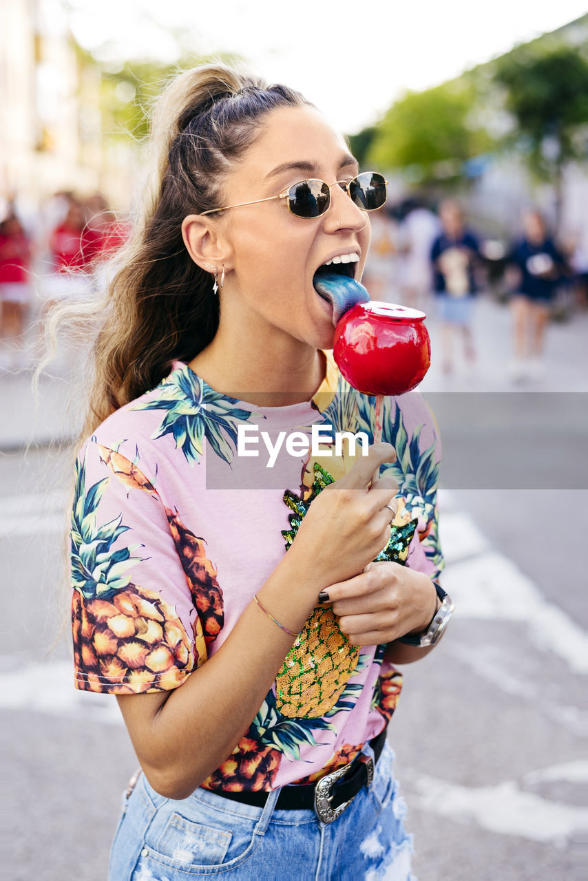 Cheerful lady having fun enjoying sweet candy apple