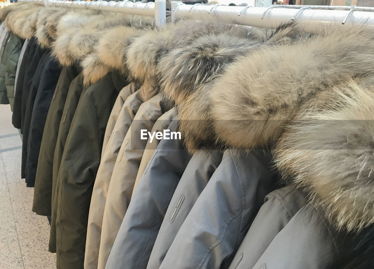 Close-up of fur coats hanging on rack