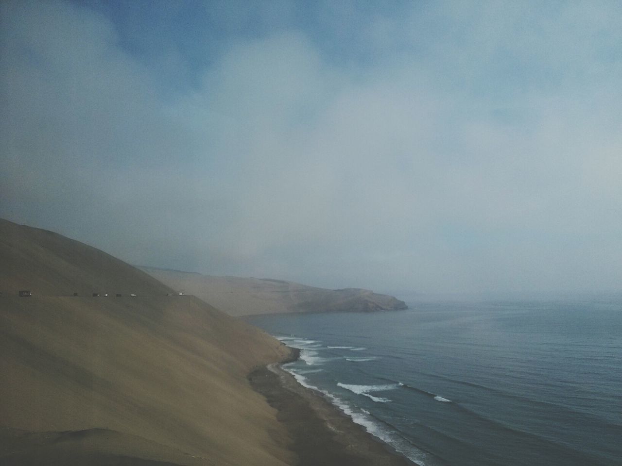 Scenic view of sea and mountain against sky