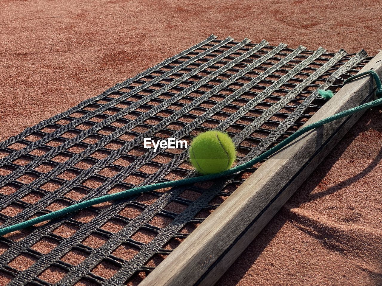 HIGH ANGLE VIEW OF GREEN BALL AND LEAF ON FOOTPATH