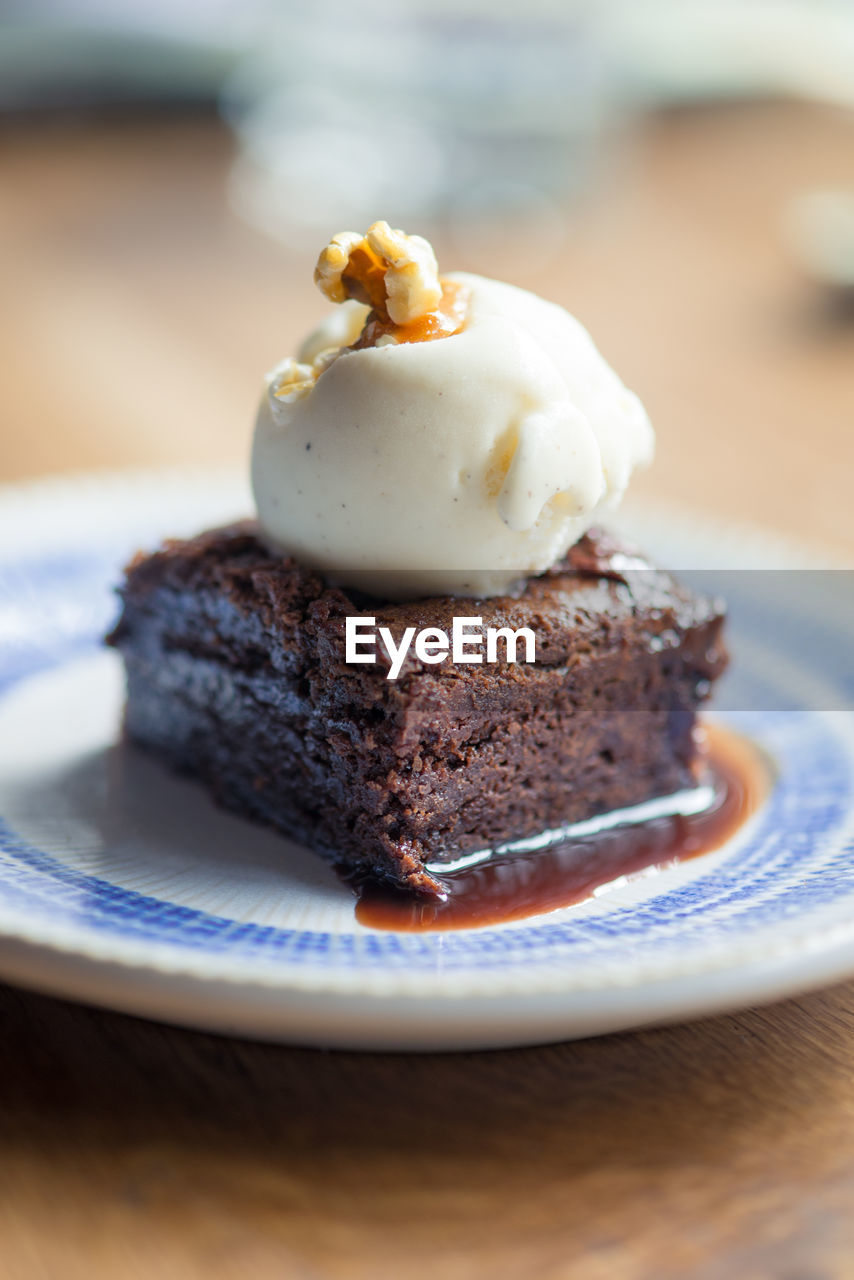 Close-up of chocolate brownie with vanilla ice cream in plate on table