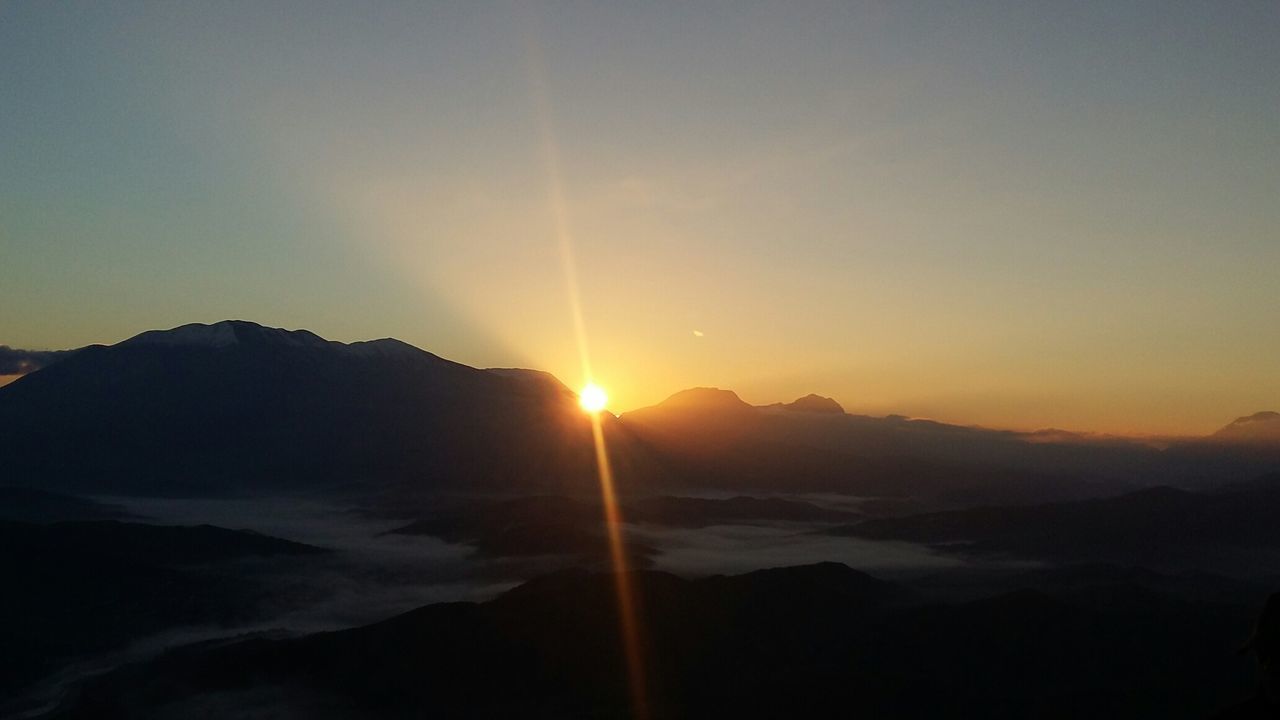 Scenic view of mountains against clear sky during sunset