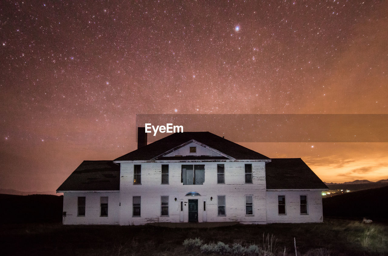 HOUSES AGAINST SKY AT NIGHT