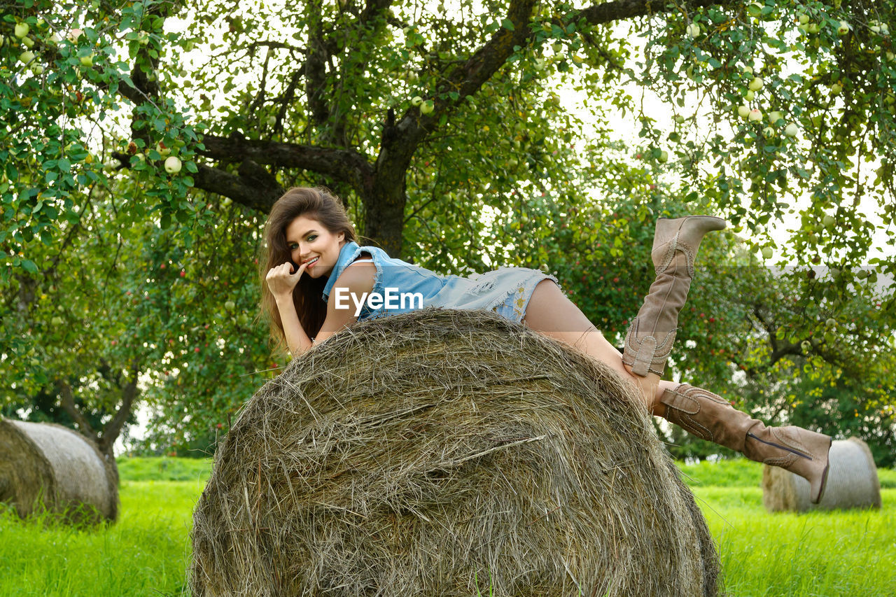 portrait of young woman standing on field