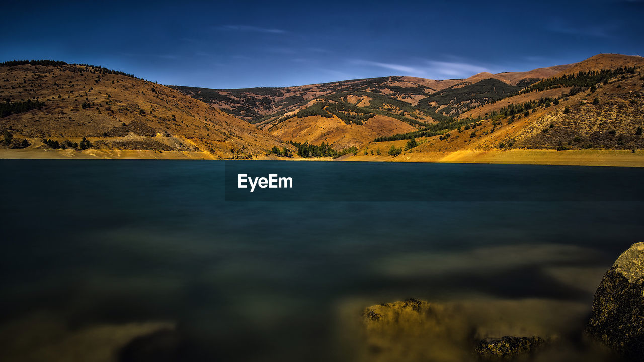 Scenic view of lake and mountains against sky