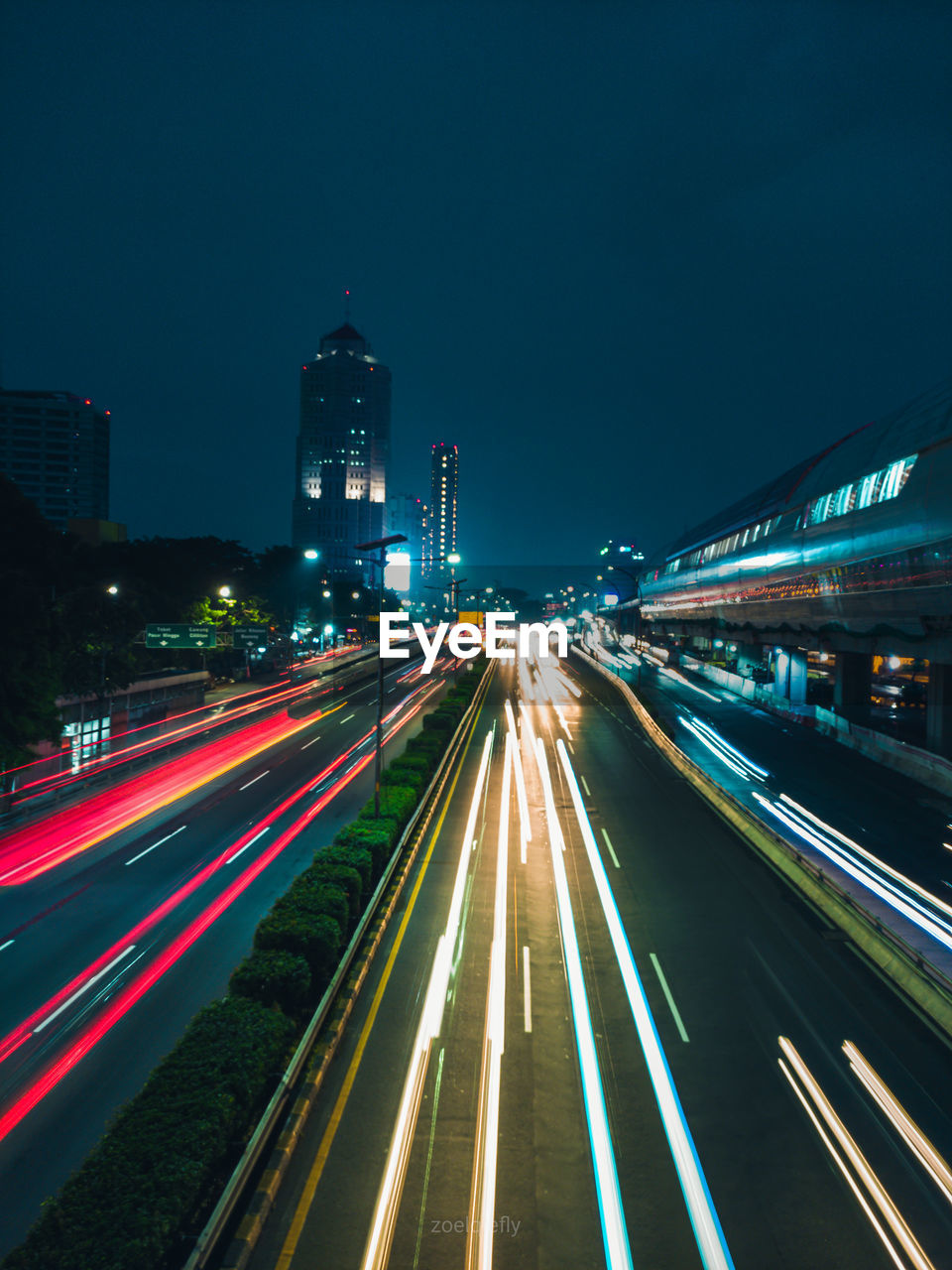 Light trails on road amidst buildings in city at night