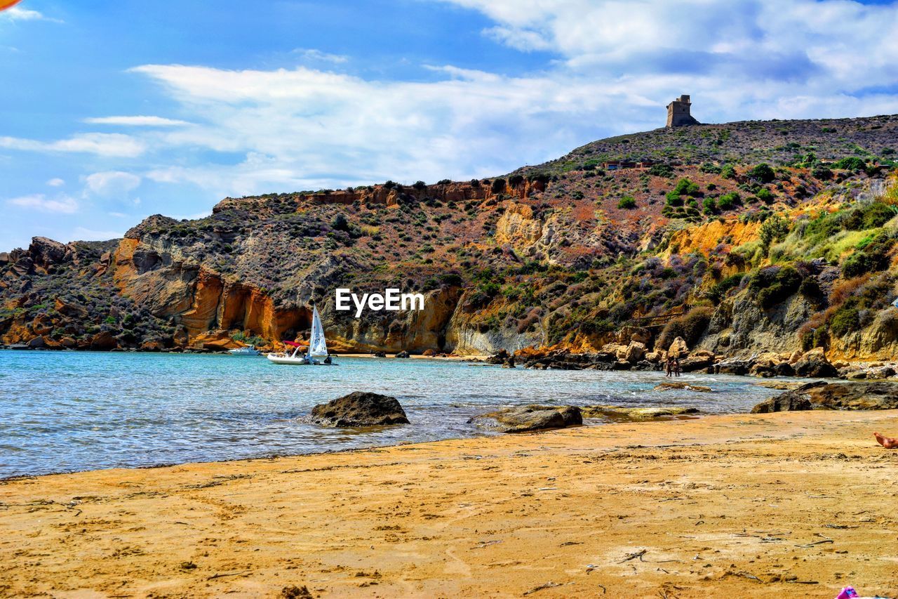 SCENIC VIEW OF SEA AGAINST MOUNTAIN