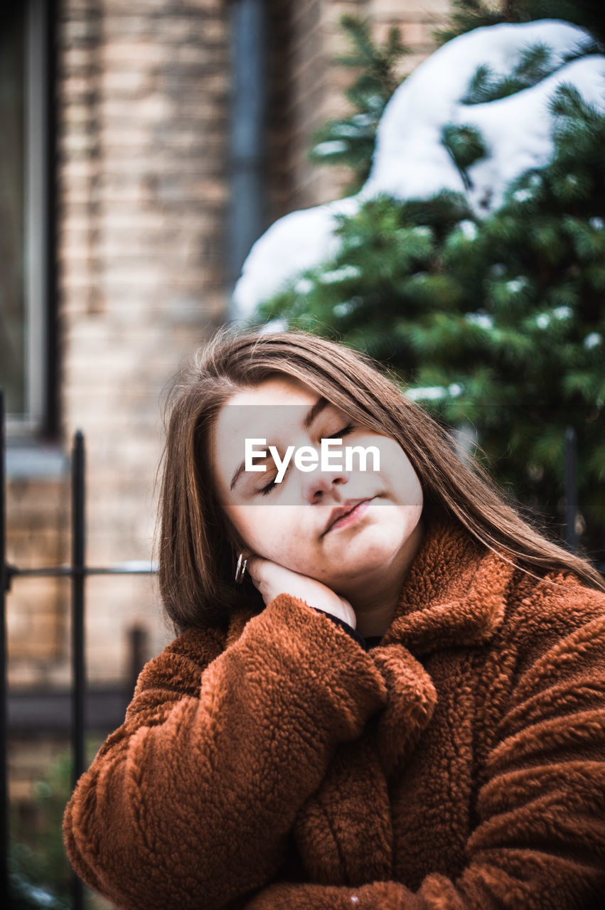 Close-up of young woman wearing warm clothing while standing outdoors