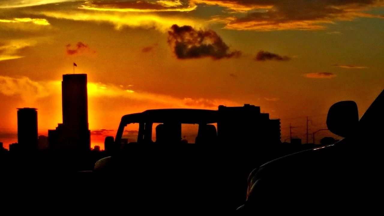 SILHOUETTE OF FACTORY AGAINST SKY AT SUNSET