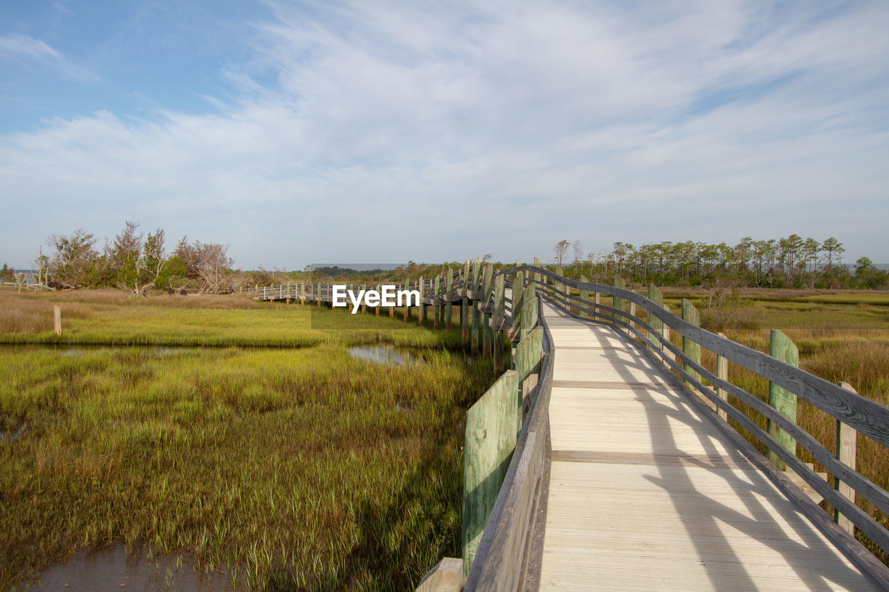 Scenic view of coastal marsh against sky with boardwalk hiking trail 