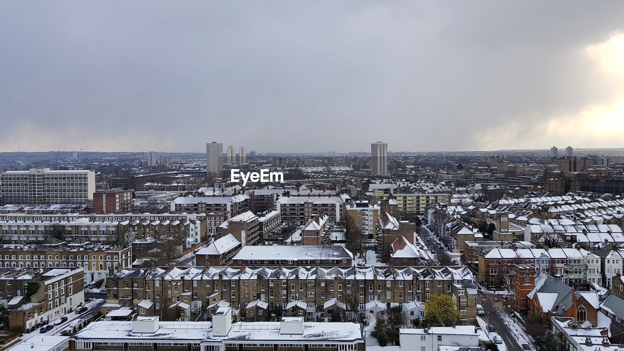 Aerial view of cityscape against sky during winter