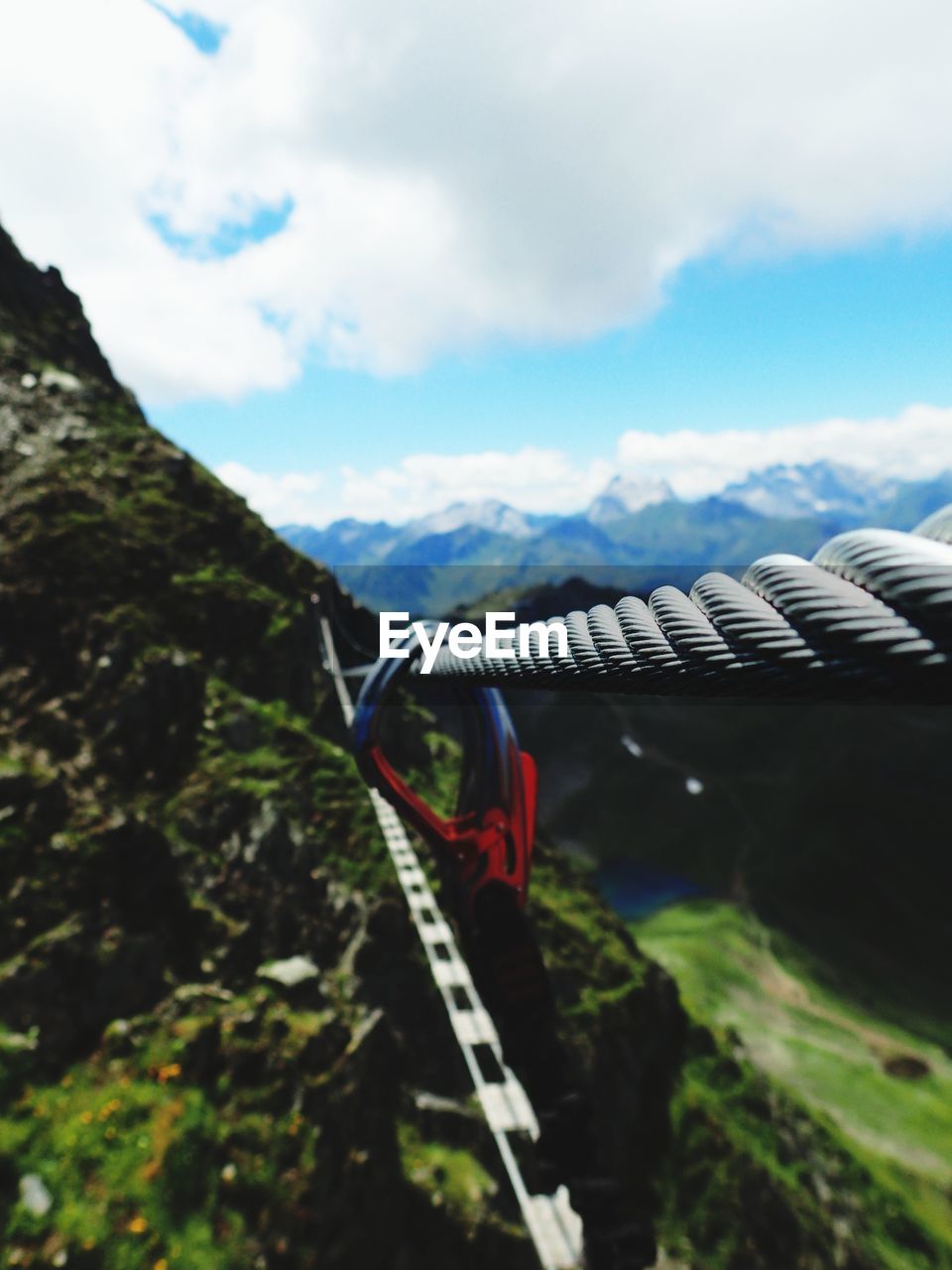 Close-up of rope hanging on mountain against sky