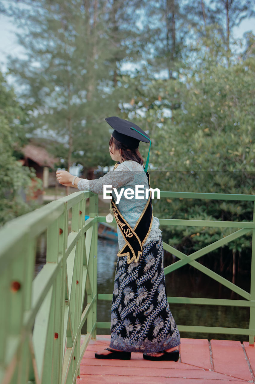 Rear view of woman standing on footbridge