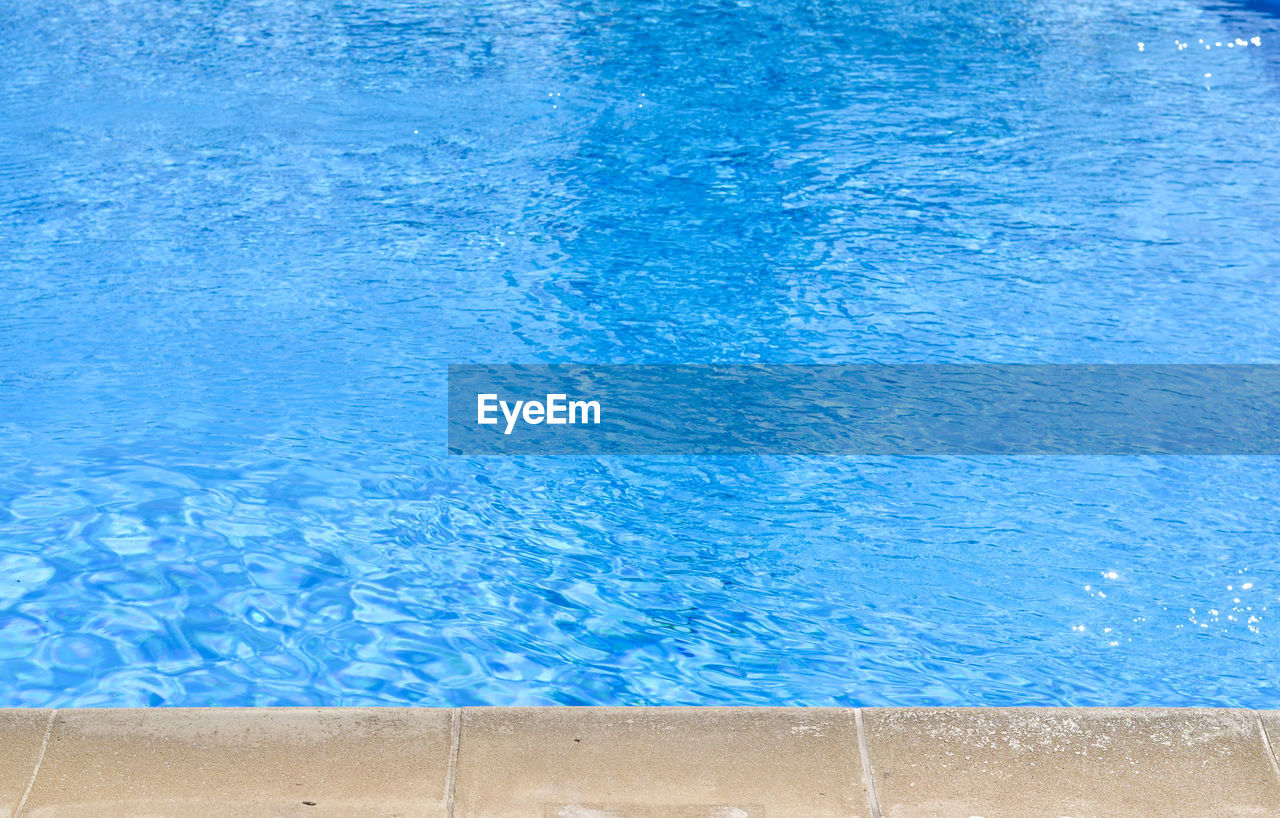 HIGH ANGLE VIEW OF SWIMMING POOL IN RIPPLED WATER