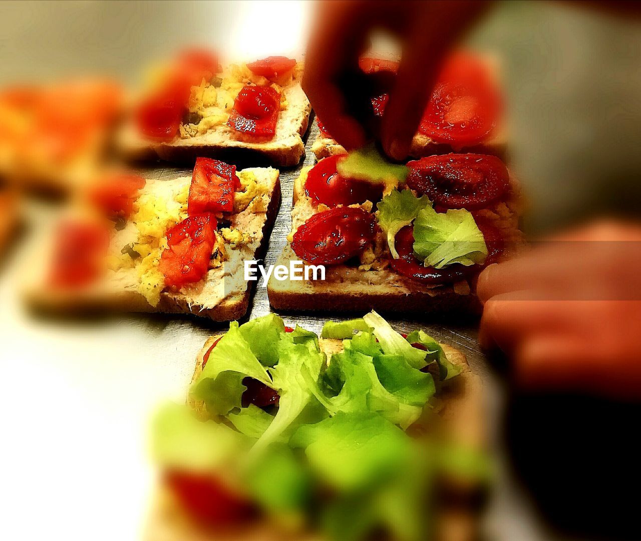 CLOSE-UP OF HAND HOLDING TOMATO