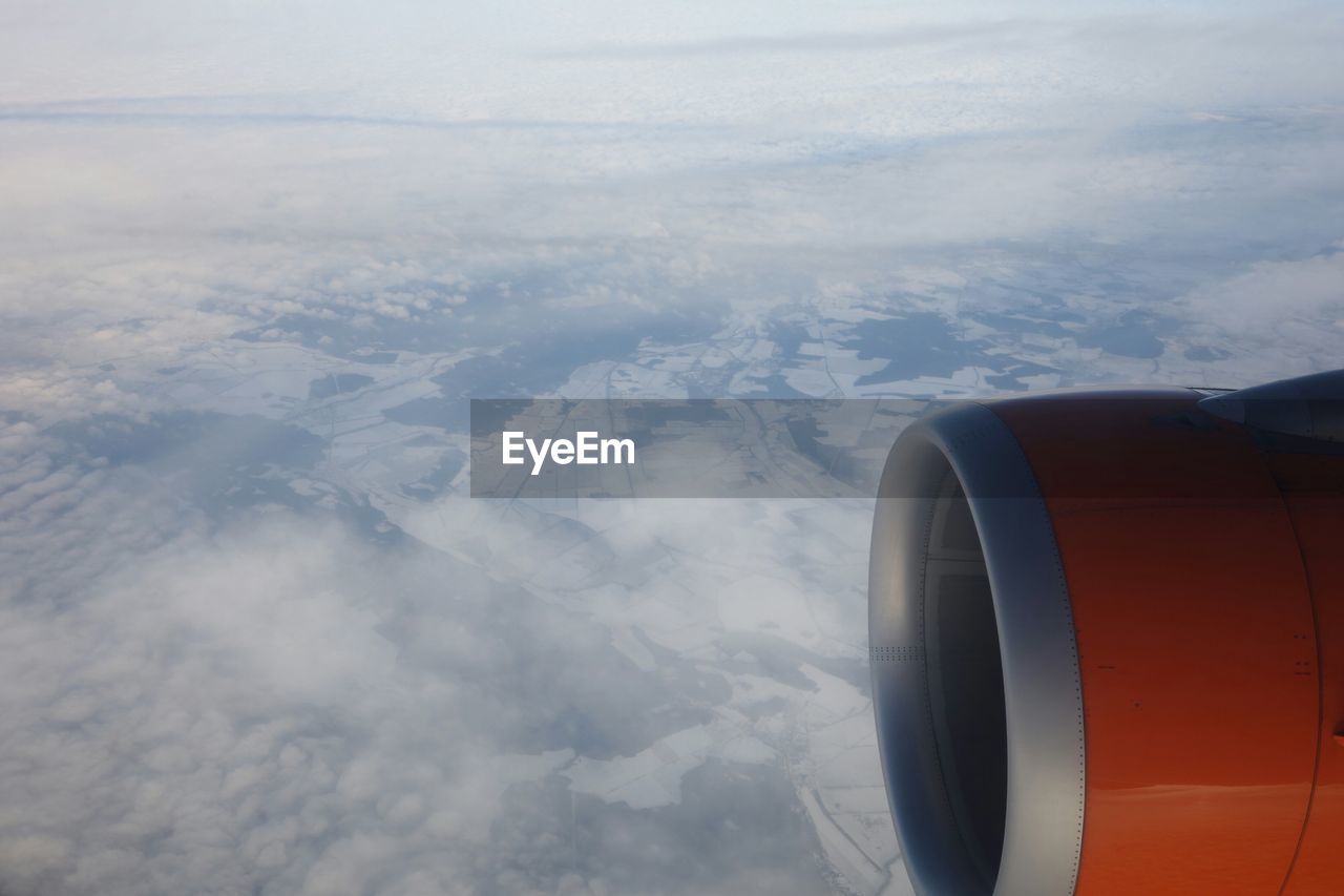 Cropped jet engine flying in sky