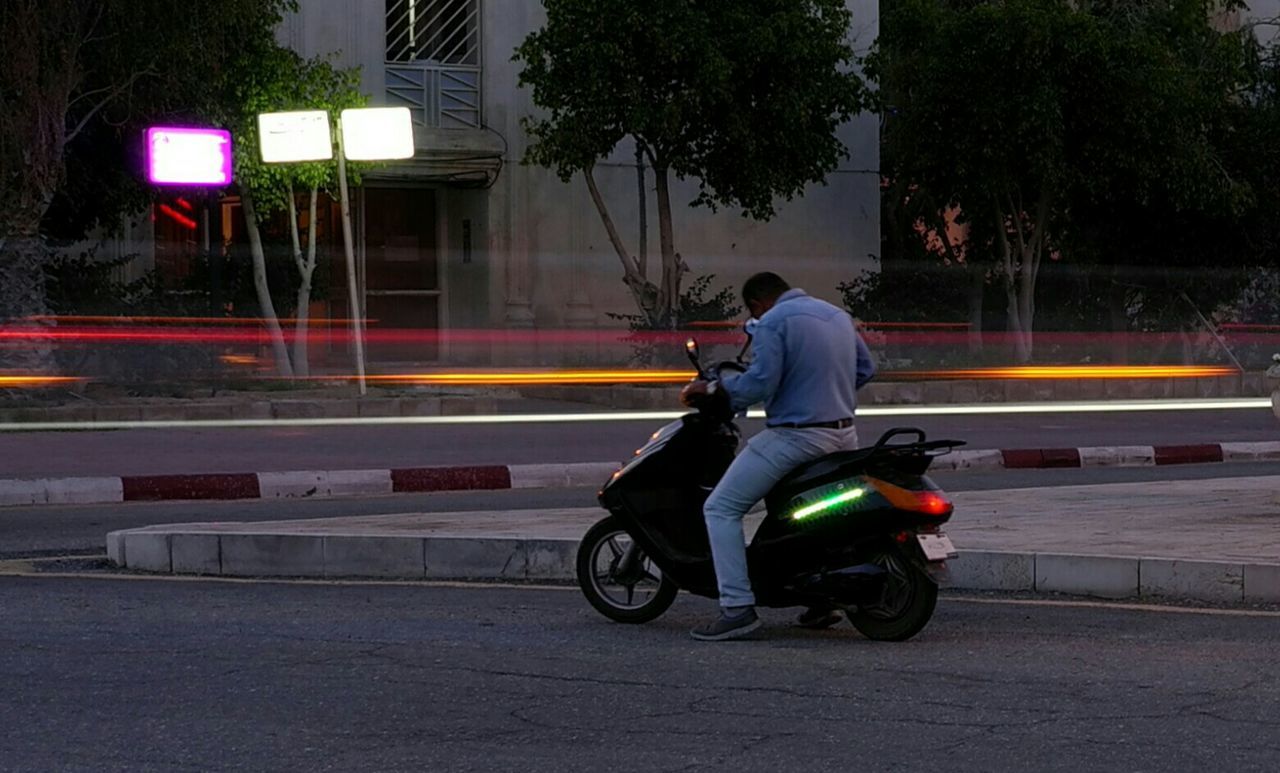 MAN WITH MOTORCYCLE ON ROAD AGAINST SKY