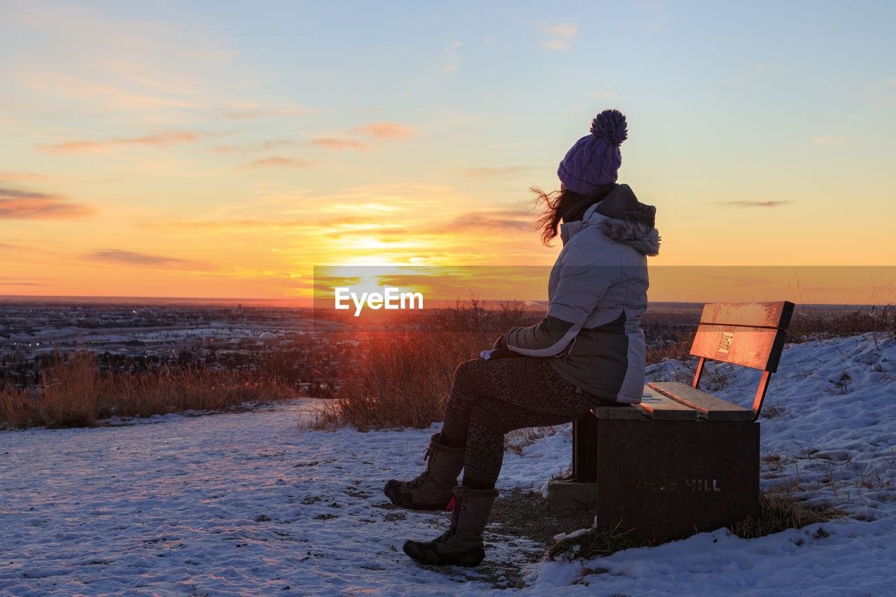 Woman sitting on a bench on a wintry morning