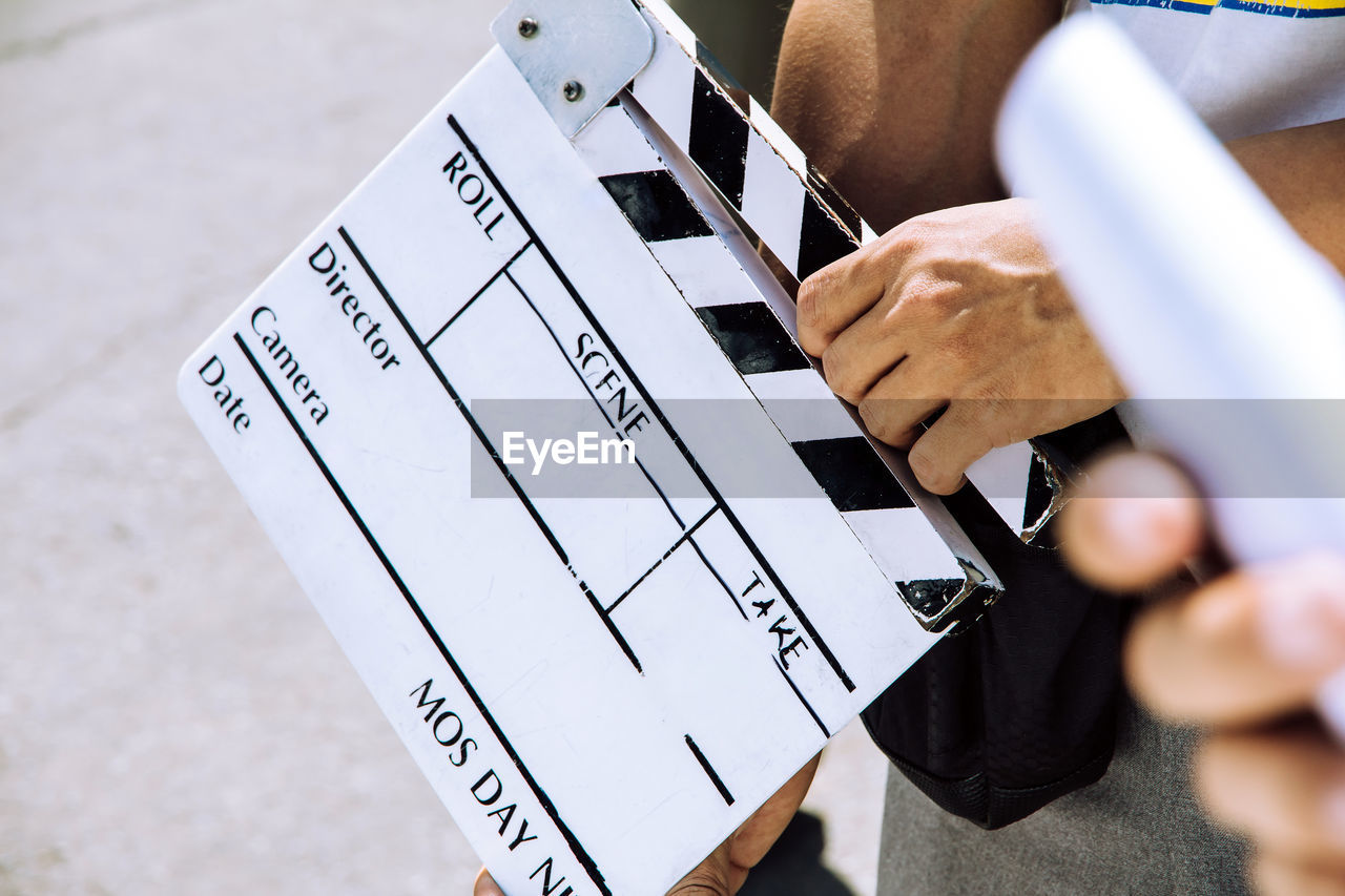 Close up image of film production crew holding film slate on set