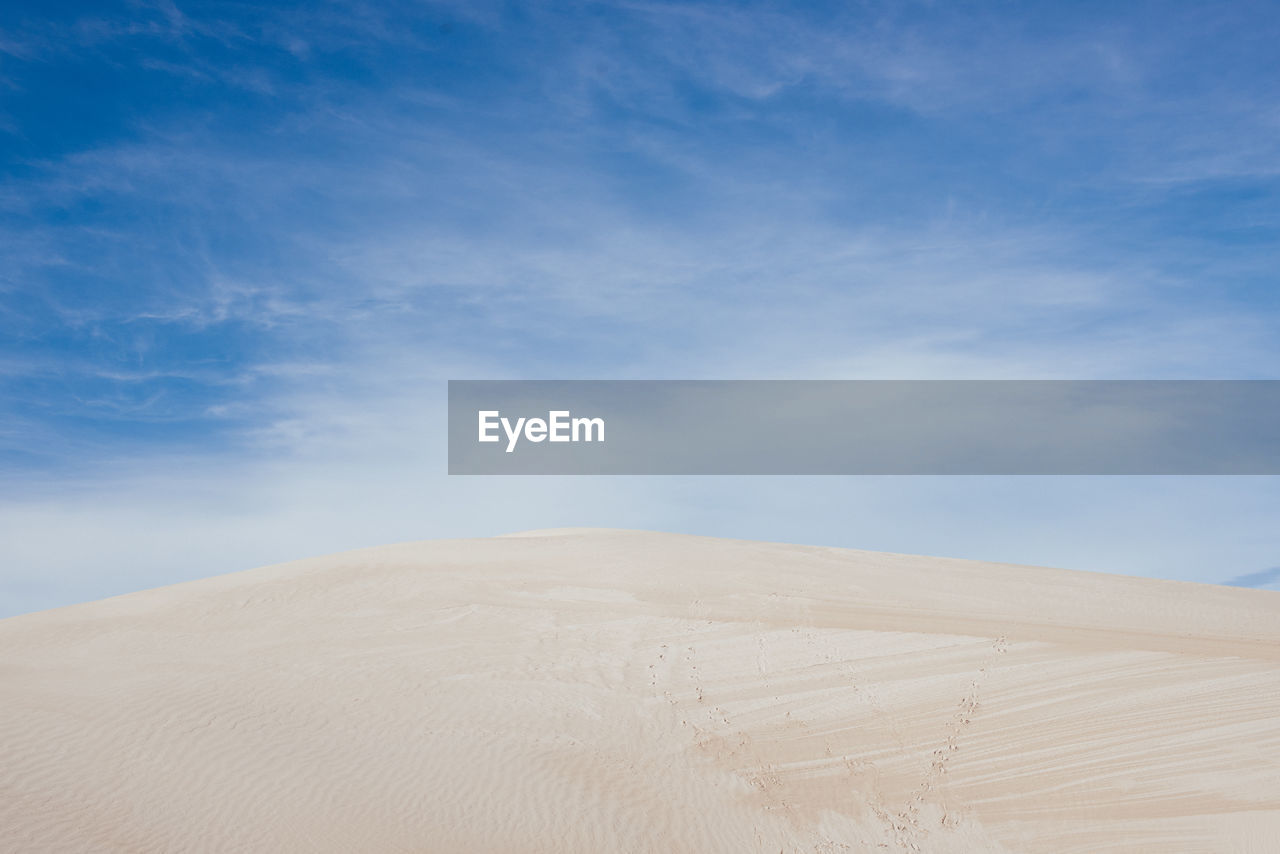 Scenic view of desert against blue sky