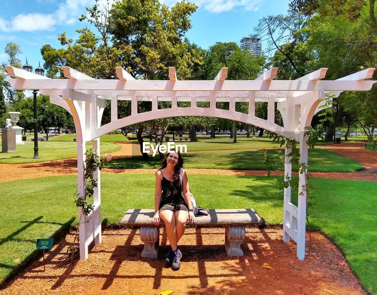 Full length of young woman on seat at park