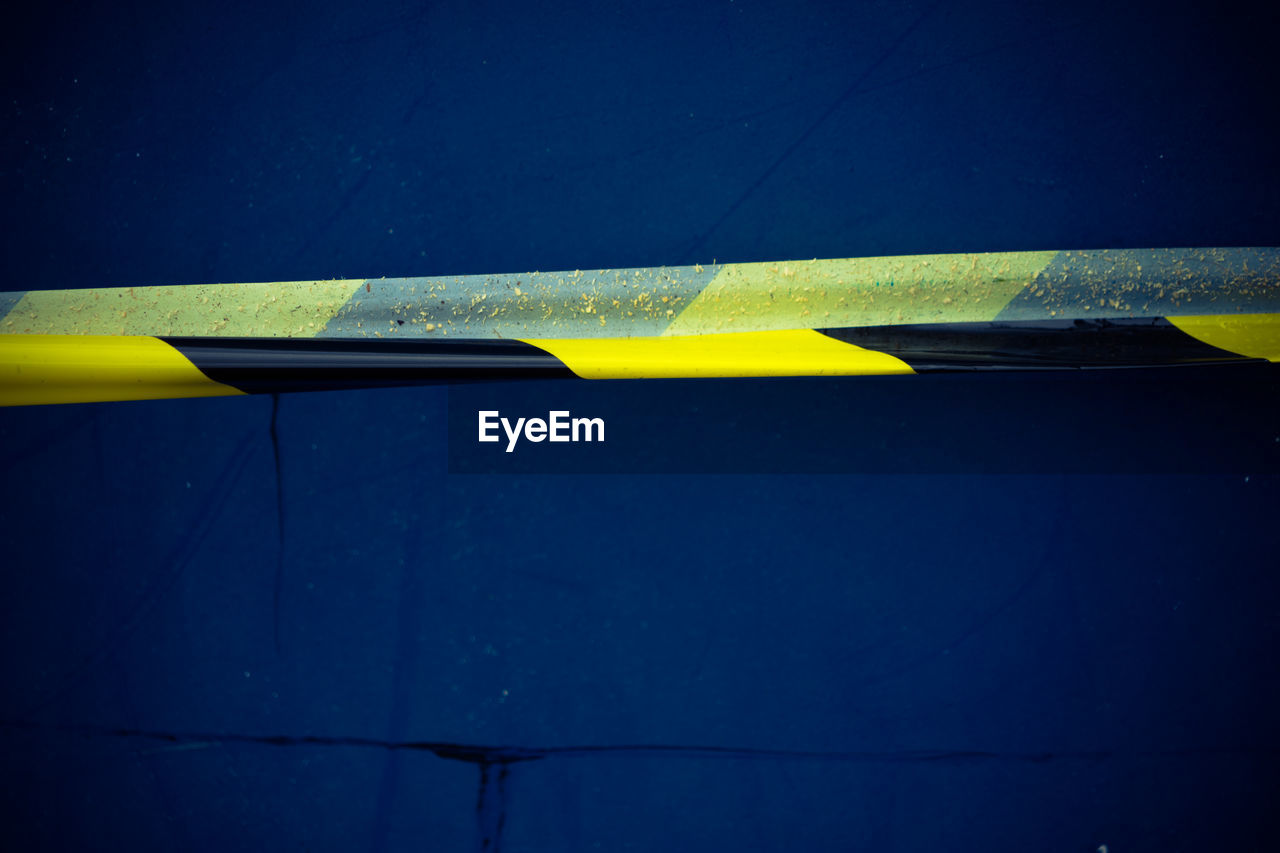Close-up of cordon tape against blue wall