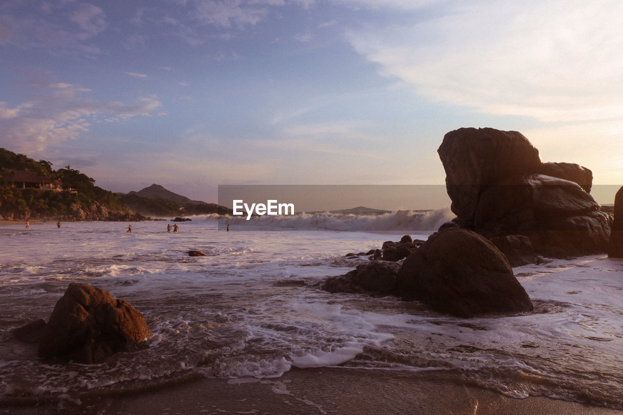 SCENIC VIEW OF ROCKS ON BEACH AGAINST SKY