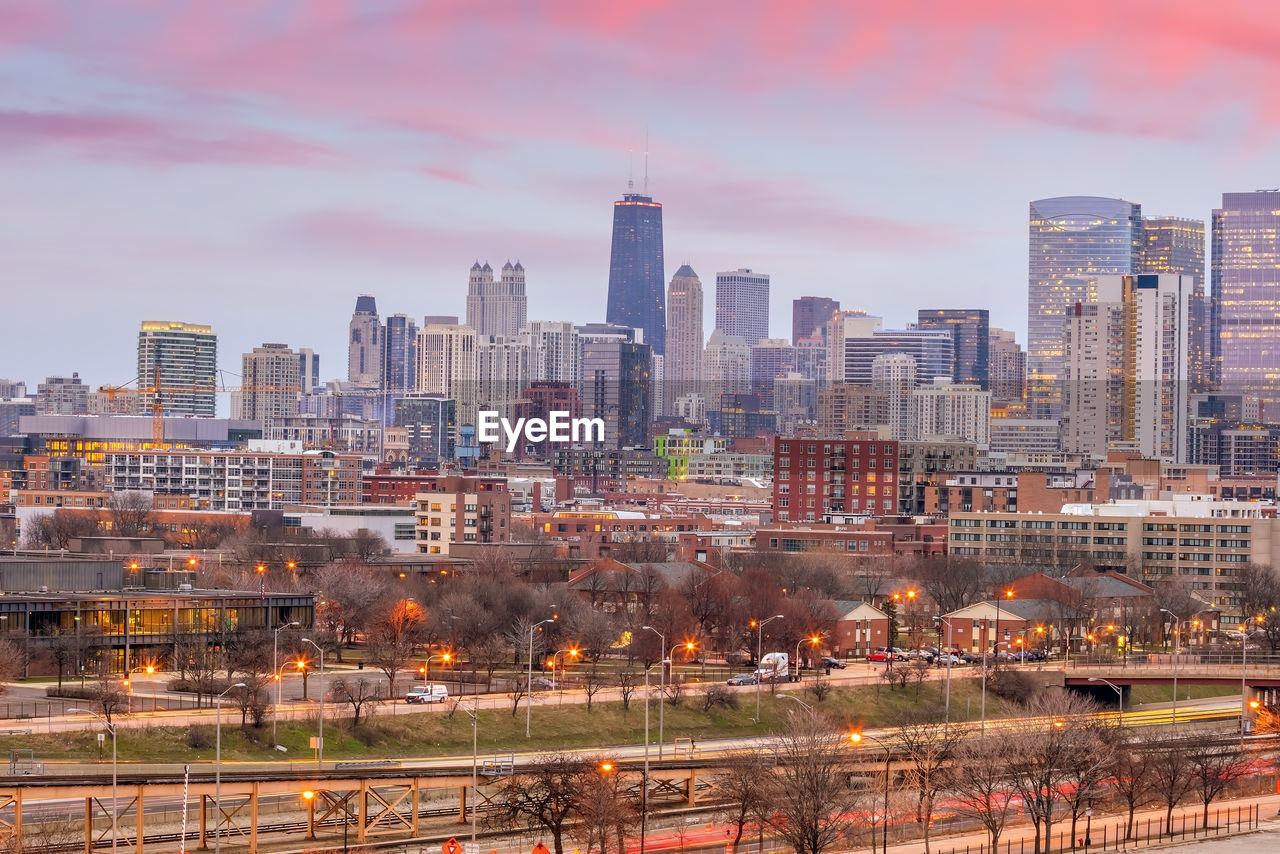 MODERN BUILDINGS IN CITY AGAINST SKY DURING ORANGE SKYLINE