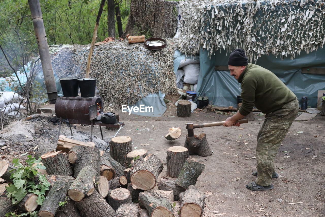 Man cutting logs at forest