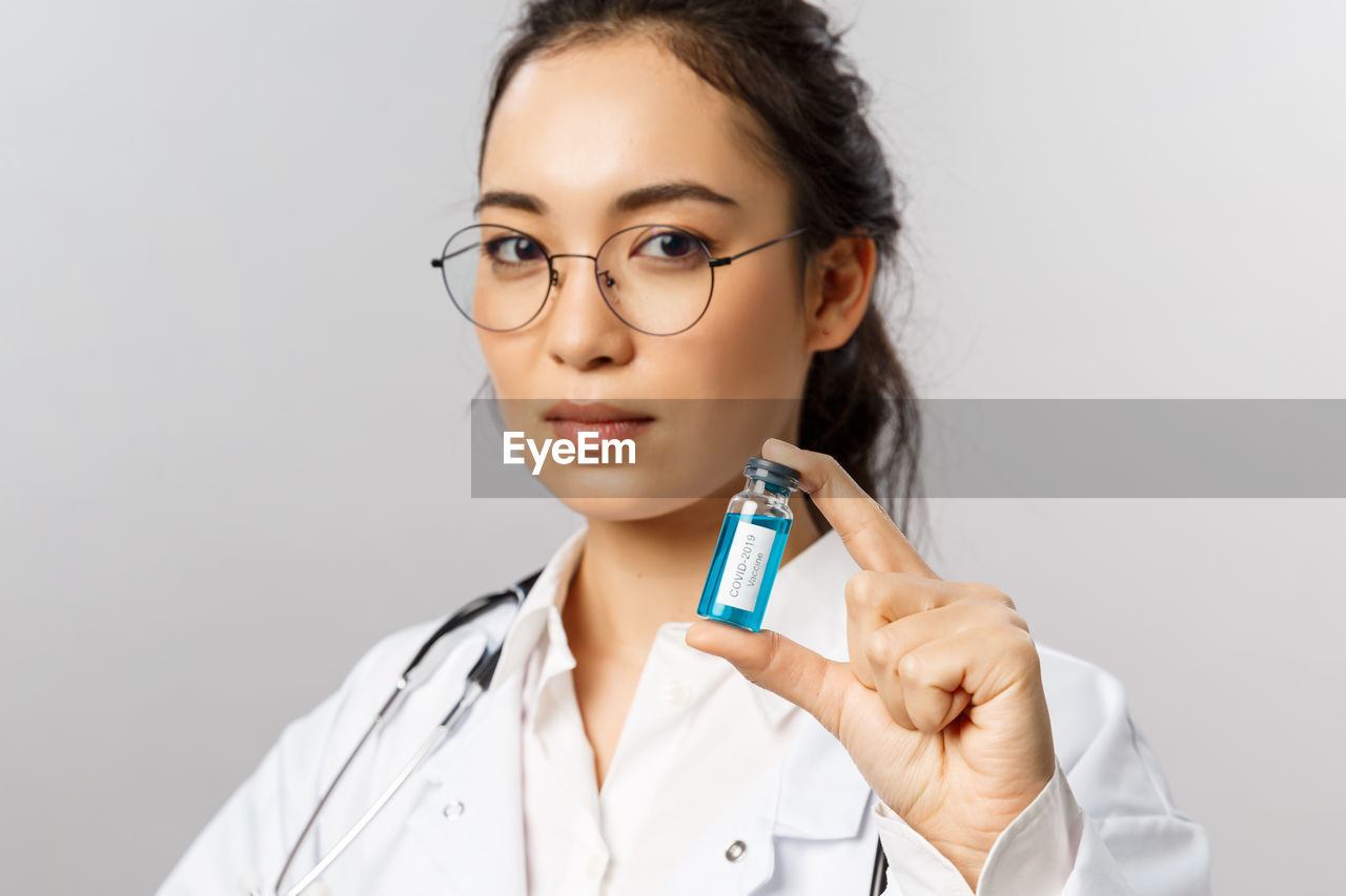 Portrait of young doctor against white background