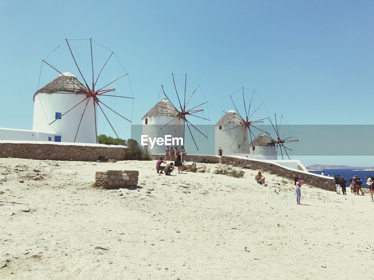 TRADITIONAL WINDMILL AT BEACH AGAINST CLEAR SKY