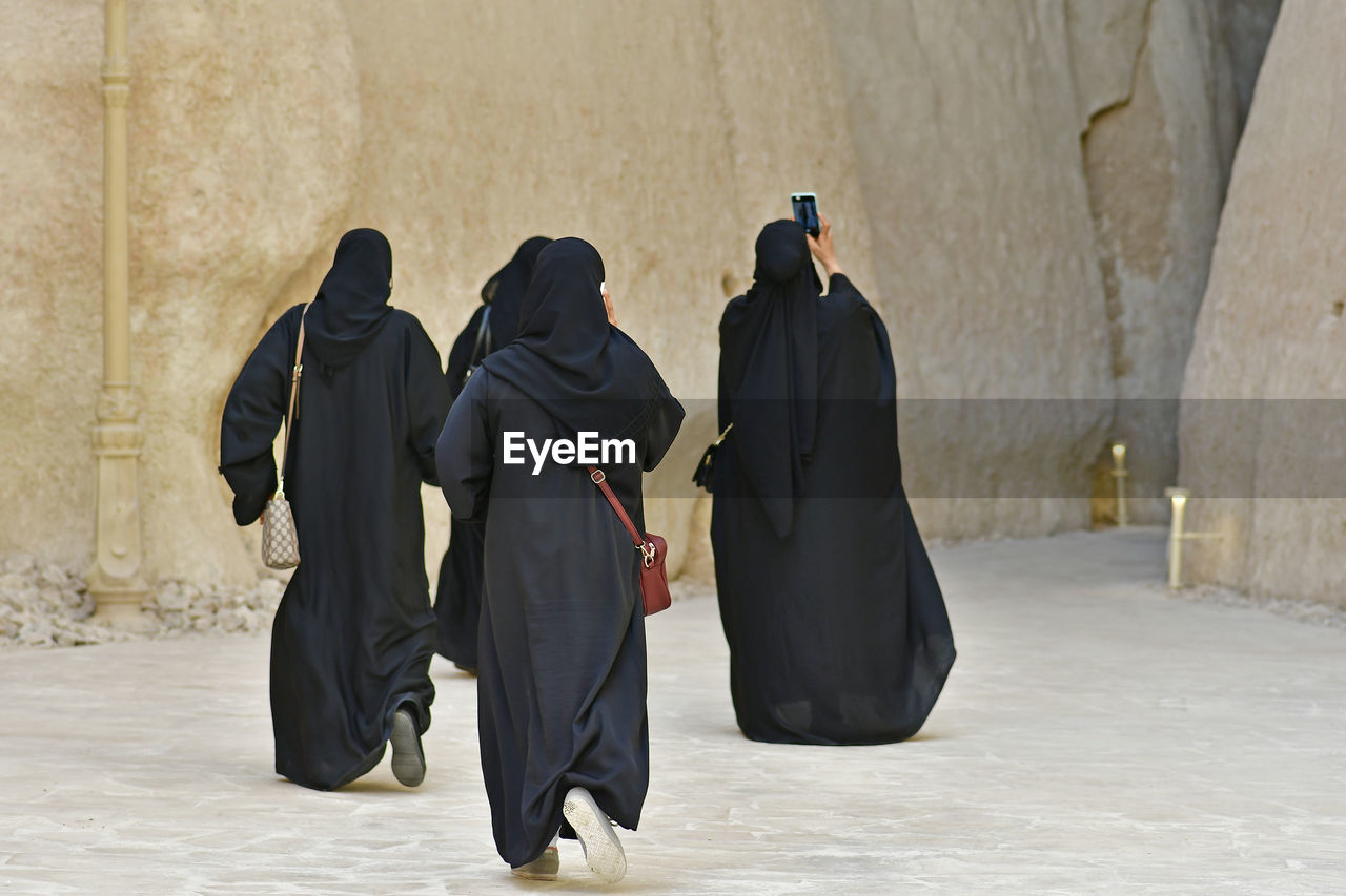 Rear view of women wearing burka against built structure