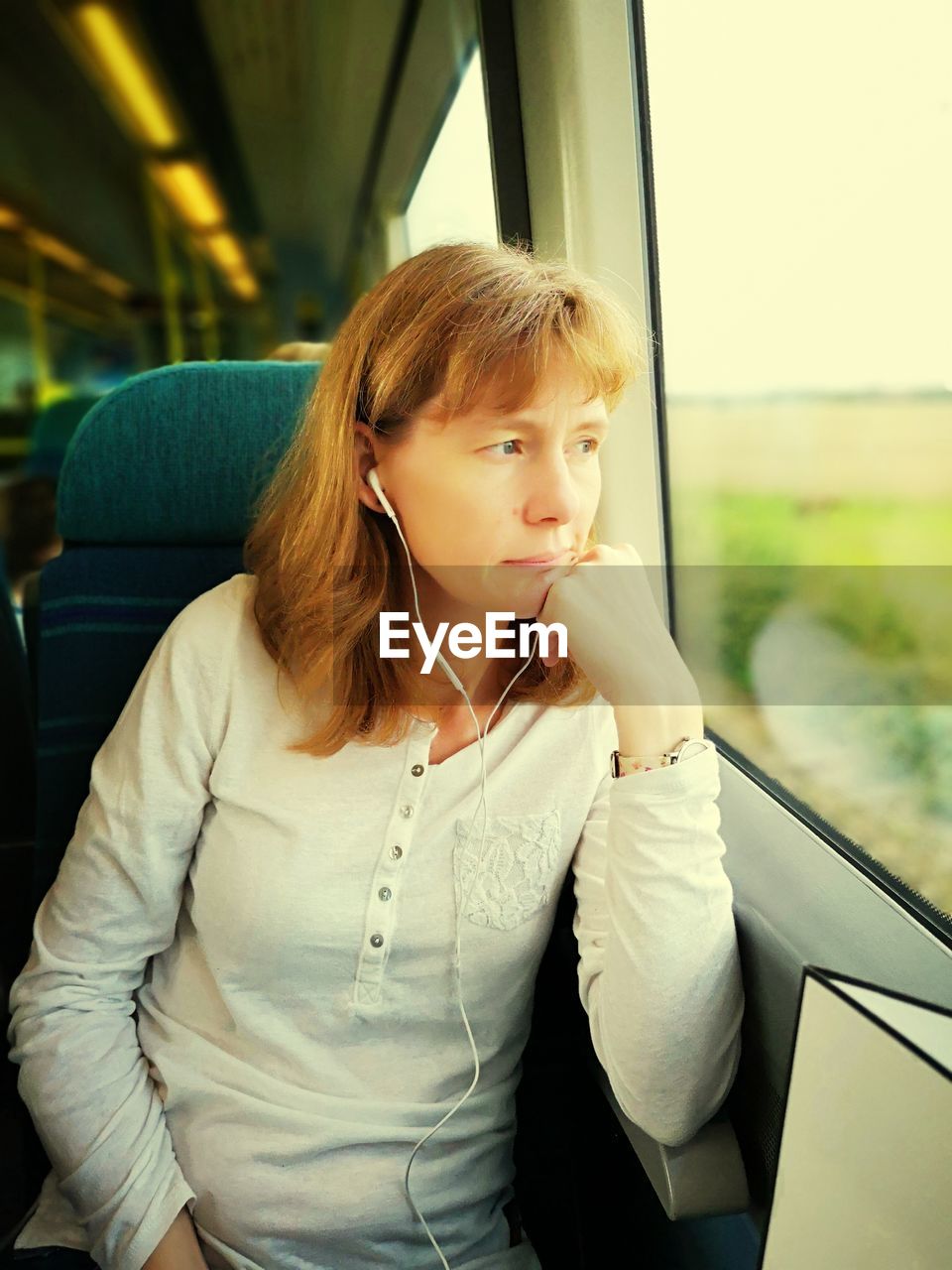 Woman looking through window while traveling in train