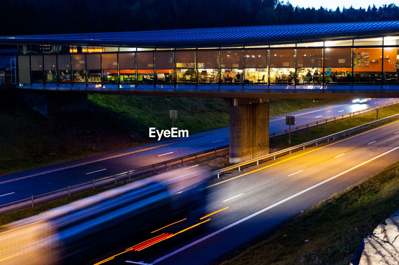 Illuminated marche holmestrand cafe over highway at dusk