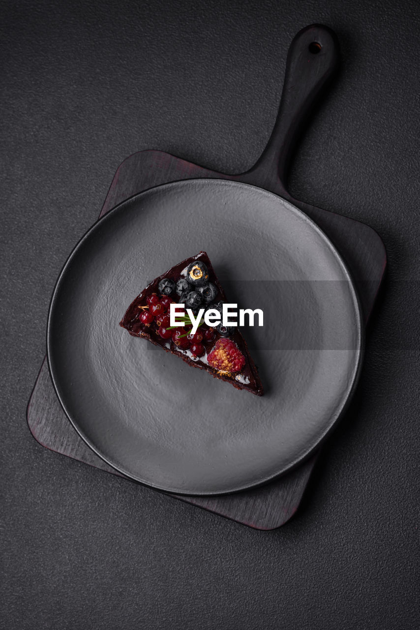 food, food and drink, studio shot, plate, healthy eating, gray, fruit, indoors, kitchen utensil, freshness, no people, wellbeing, sweet food, high angle view, directly above, gray background, sweet, eating utensil, berry, still life, red, dessert, household equipment, black background