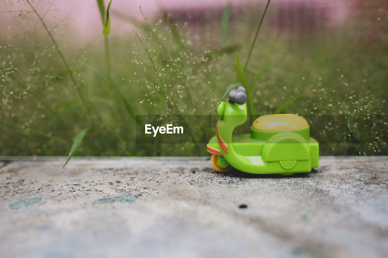 CLOSE-UP OF TOY ON GRASSY FIELD