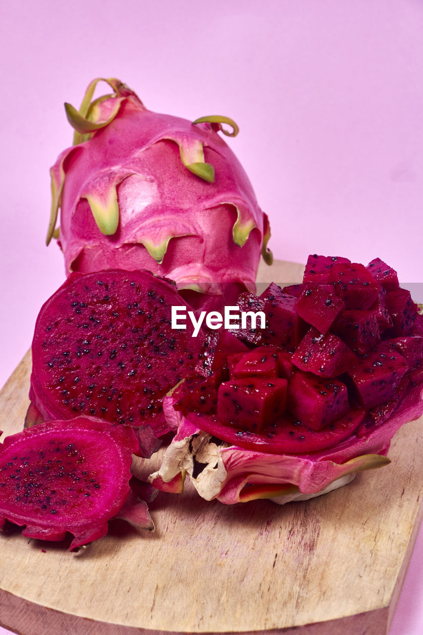 Red dragon fruit set with appetizing serving on pink background. top view