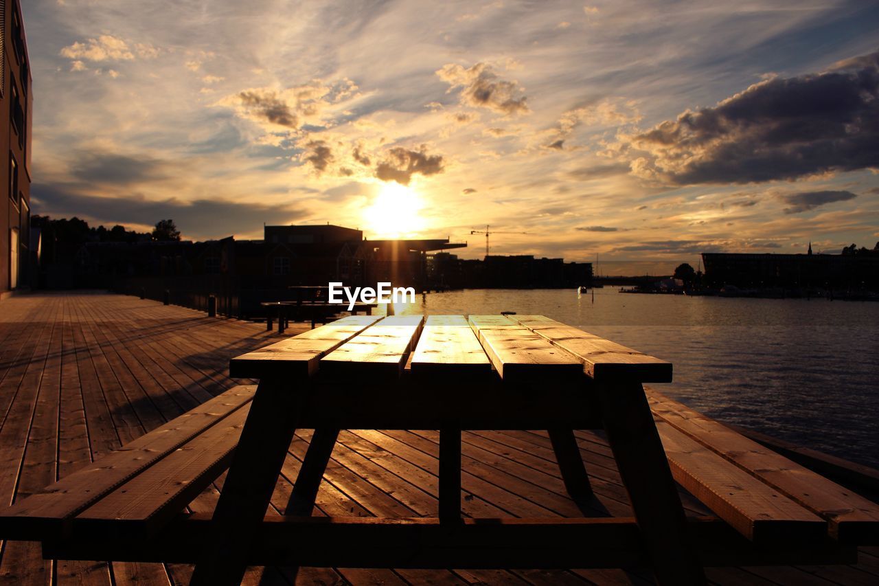 JETTY ON TABLE BY LAKE AGAINST SKY