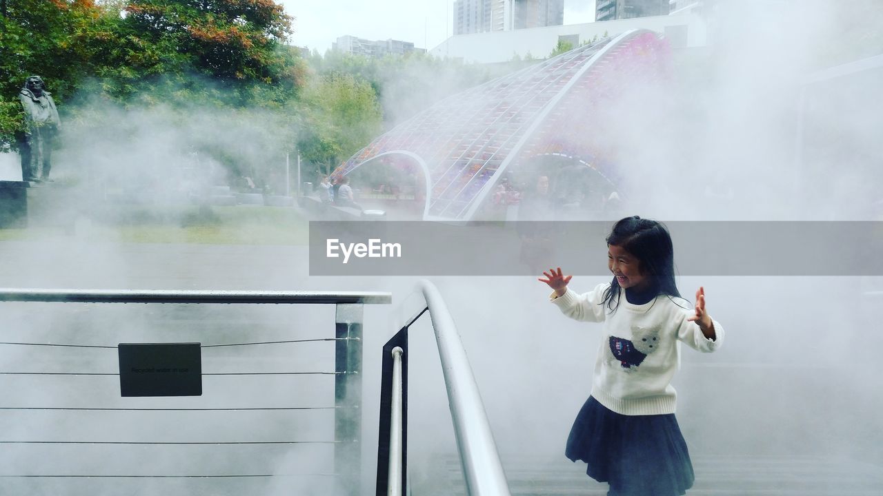 Girl standing against fountain in park